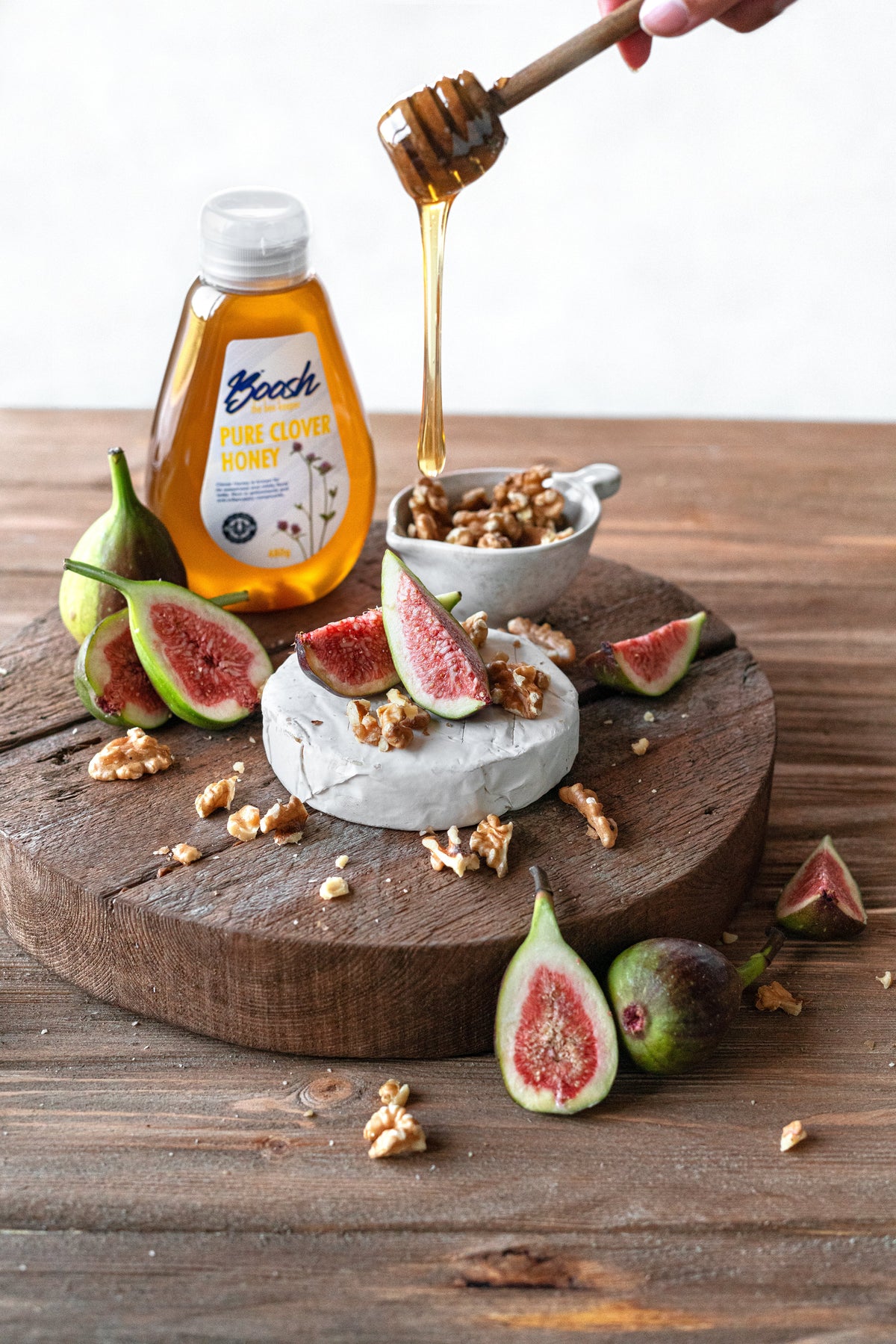 Boosh the Beekeeper clover honey and Rammah Farms olive oil on a cheese board with figs and walnuts