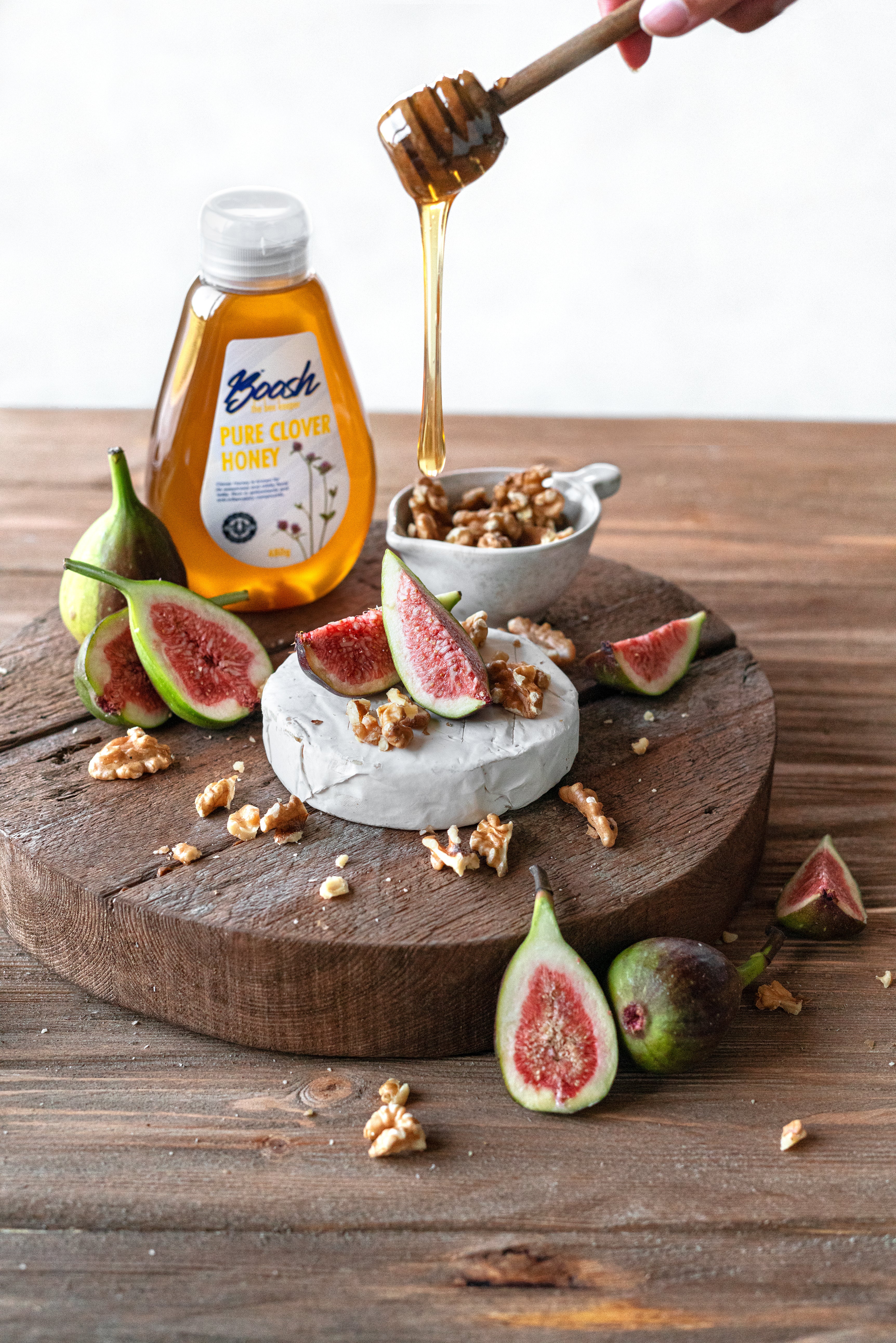 Boosh the Beekeeper clover honey and Rammah Farms olive oil on a cheese board with figs and walnuts