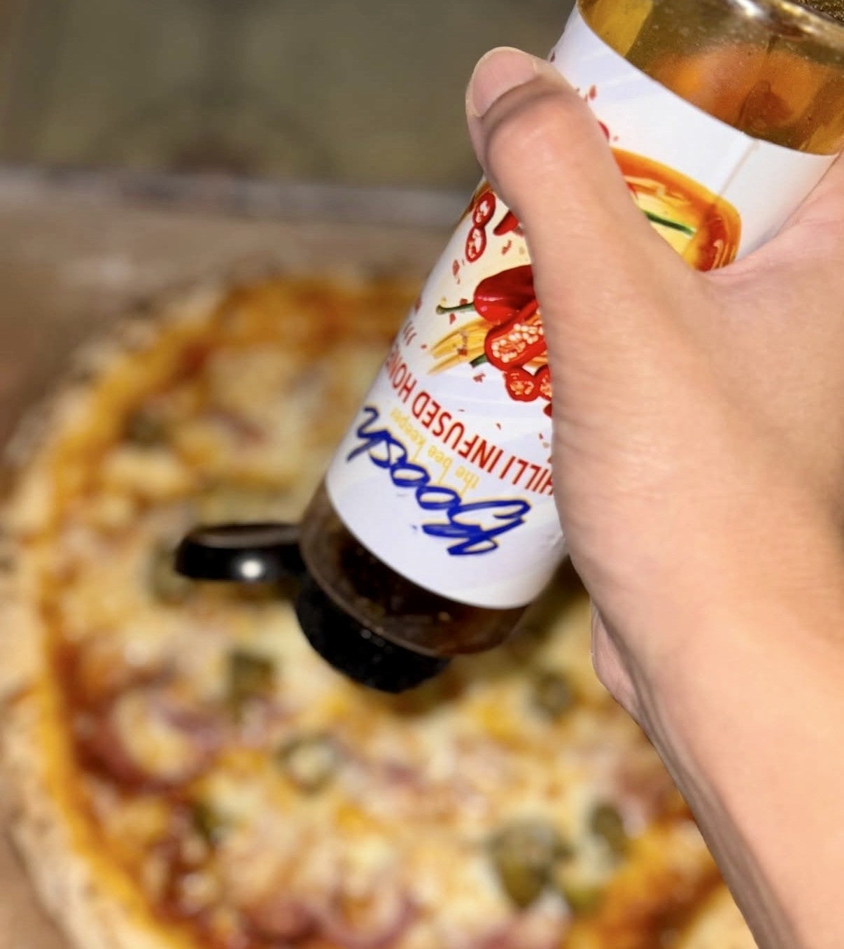 Boosh the Beekeeper chilli honey drizzled over a hot pizza slice, a slow thread of amber