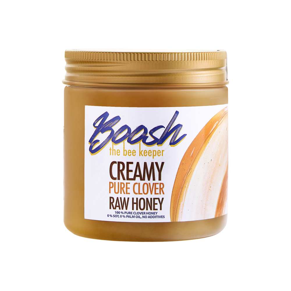 Jar of creamy pure clover raw honey with a label on a white background